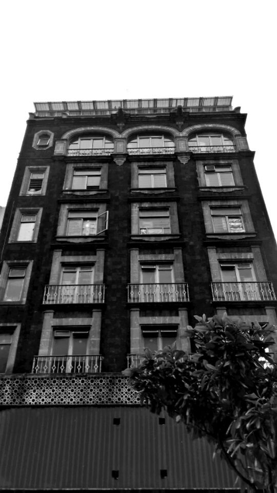 building exterior, architecture, built structure, low angle view, window, clear sky, building, residential building, facade, day, sky, residential structure, outdoors, no people, city, glass - material, balcony, in a row, architectural feature, pattern