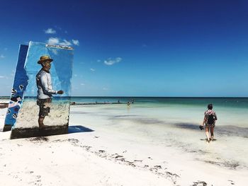 People on beach against sky