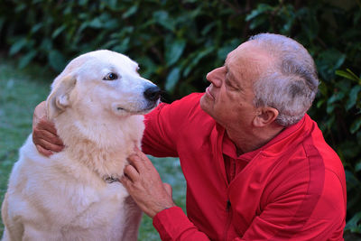 Close-up of senior man petting dog at park