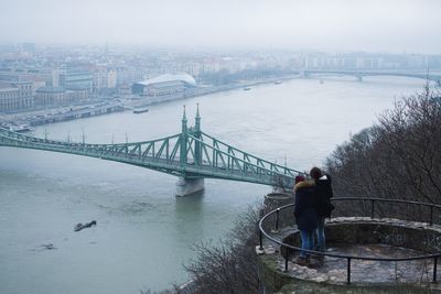 Man standing on bridge in city