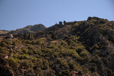 Low angle view of rocky mountain against clear sky