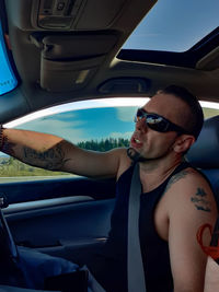 Portrait of young man sitting in car