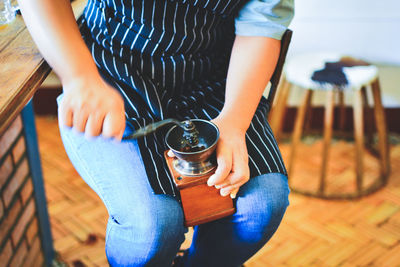 Midsection of woman holding food while sitting on table