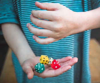 Midsection of girl holding dices