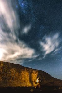 Woman standing on mountain against sky at night