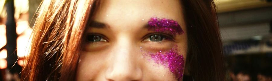 Close-up portrait of young woman with glitters on face