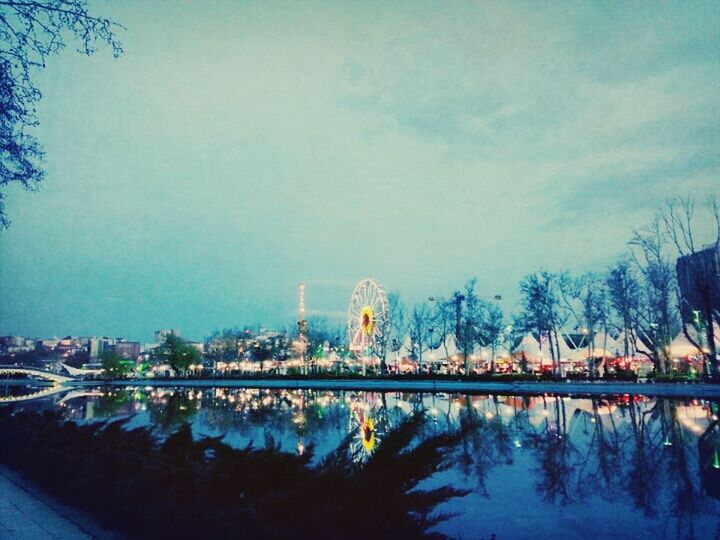 water, architecture, built structure, reflection, building exterior, tree, illuminated, sky, river, lake, waterfront, city, blue, night, dusk, standing water, clear sky, outdoors, nature, bridge - man made structure