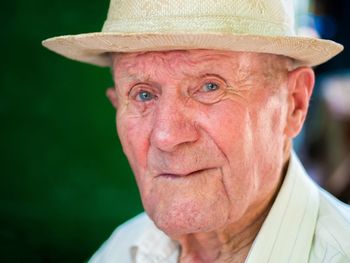 Close-up portrait of senior man wearing hat
