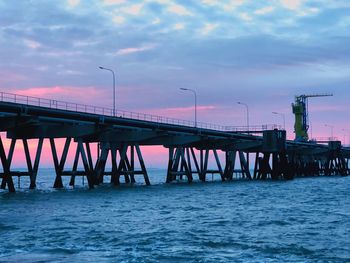 Pier over sea against sky during sunset