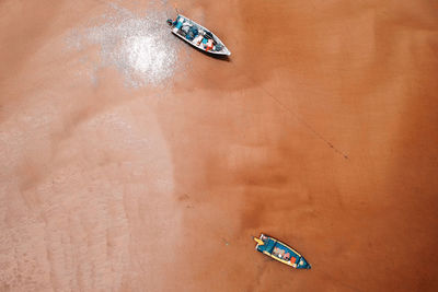 Directly above shot of rowboats on sand at beach