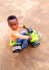 High angle view of cute boy riding toy toys