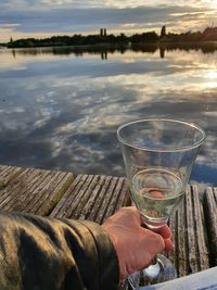 Reflection of hand holding glass of water