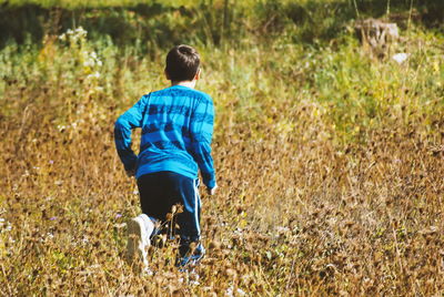 Rear view of man running on field