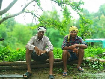 Rear view of man sitting against plants