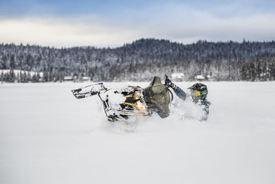 Experienced rider operates snowmobile confidently in deep snow.