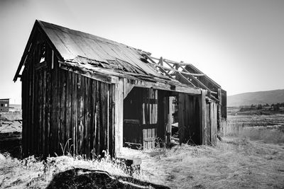 Abandoned house on field against clear sky