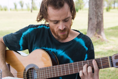 Bearded man playing guitar