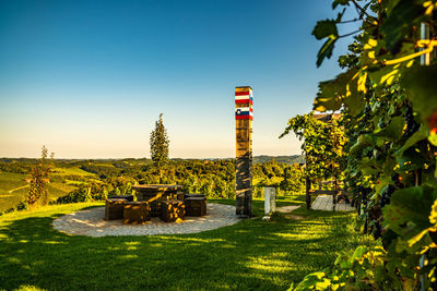 Plants and tower against clear blue sky