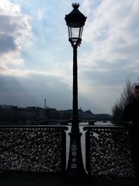 Street light against cloudy sky