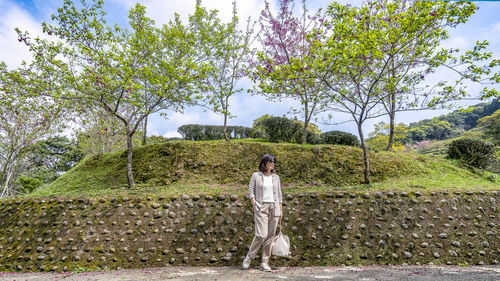 Rear view of woman standing by tree