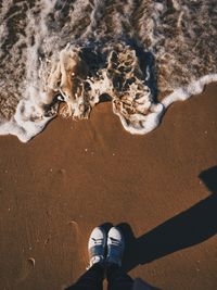 Low section of person standing on beach