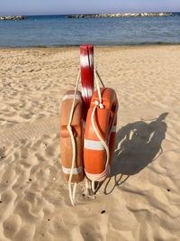 Deck chairs on beach against sky