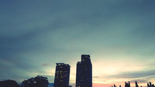 Low angle view of skyscrapers against sky during sunset