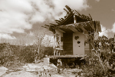 Abandoned building against cloudy sky