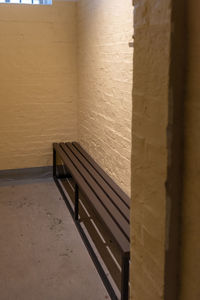 Empty bench against wall in building