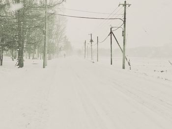 Snow covered road against sky during winter