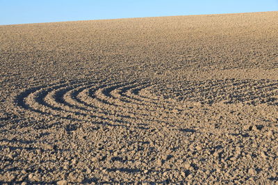 High angle view of sand dune on field against clear sky