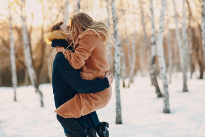 Rear view of woman standing on snow covered field