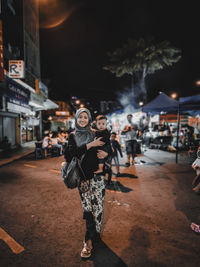 Full length of woman standing on street at night