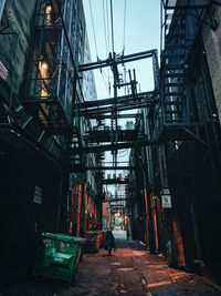 Man walking on narrow street amidst buildings in city