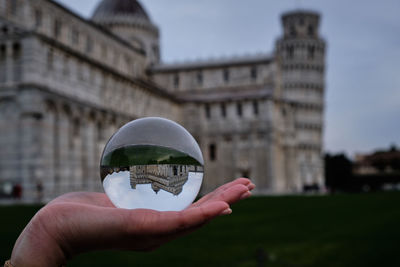 Hand holding glass of building