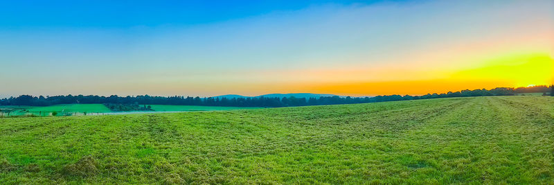 Scenic view of field against sky during sunset