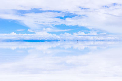 Scenic view of sea against cloudy sky during sunny day