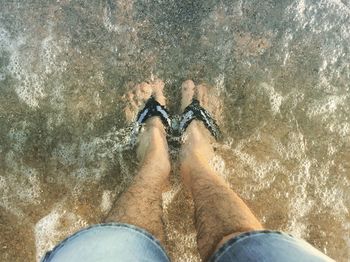 Low section of man standing on beach