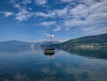 Boat moored in lake against sky