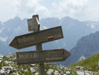 Road sign against mountain range against sky