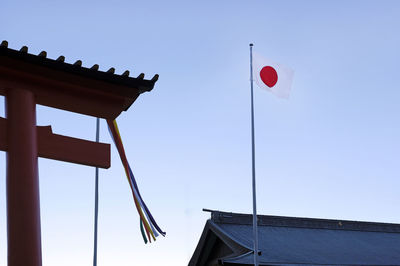 Japanese flag next to a torii at kumano nachi taisha shrine near kii-katsuura, japan