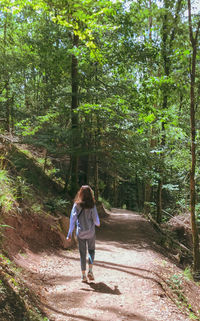 Rear view of woman walking in forest