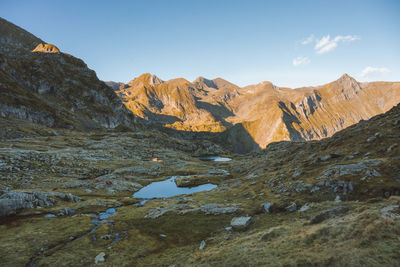 A scenic view of a mountain lake in the pyrenees during sunrise.