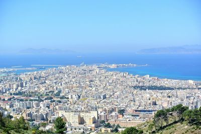 Aerial view of cityscape against clear blue sky