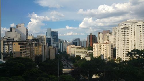 View of cityscape against cloudy sky