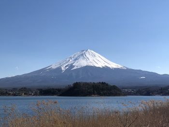 Scenic view of snowcapped mountains against clear blue sky