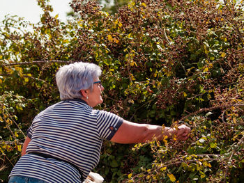 Senior woman gardening on field