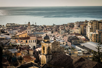 High angle view of townscape by sea against sky