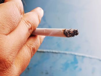 Close-up of hand holding cigarette