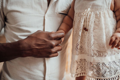 Midsection of couple holding hands